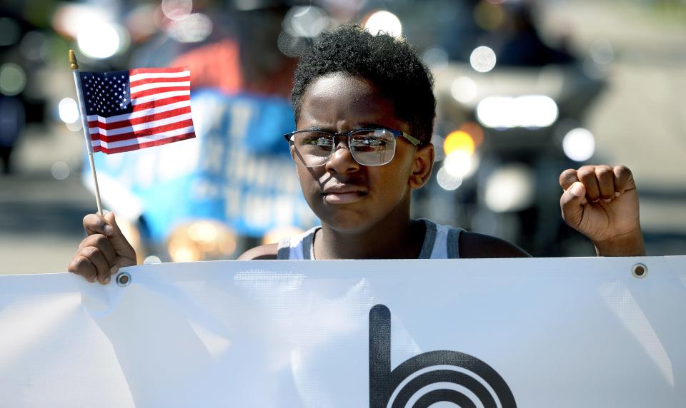 Kamren Lott, 11, of Springfield helps carrie the banner for the Juneteenth parade for the third year in a row as the parade makes its way down Martin Luther King Jr. Dr. during the Juneteenth Unity Parade and Celebration Saturday June 18, 2022.