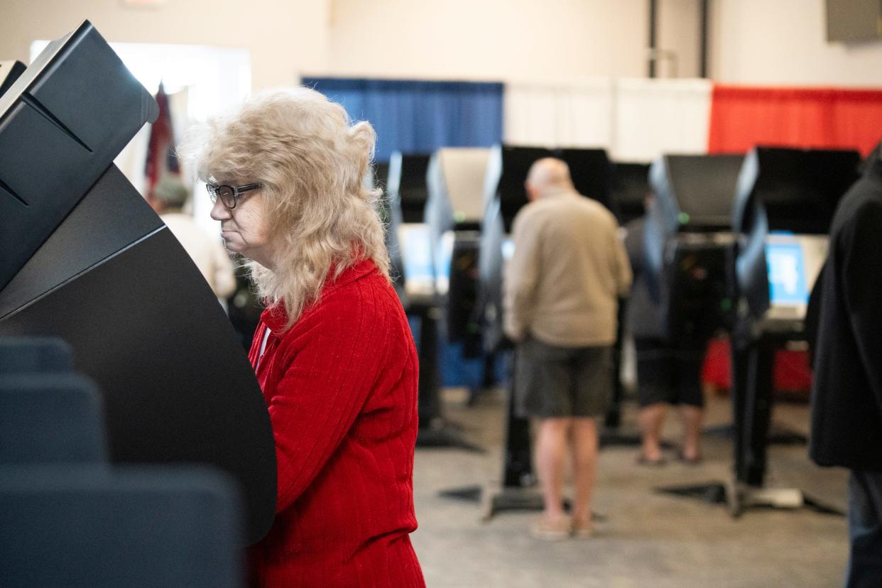 Andrea Julian, 58, of south Columbus, casts her vote on the first day of early voting for the November election.