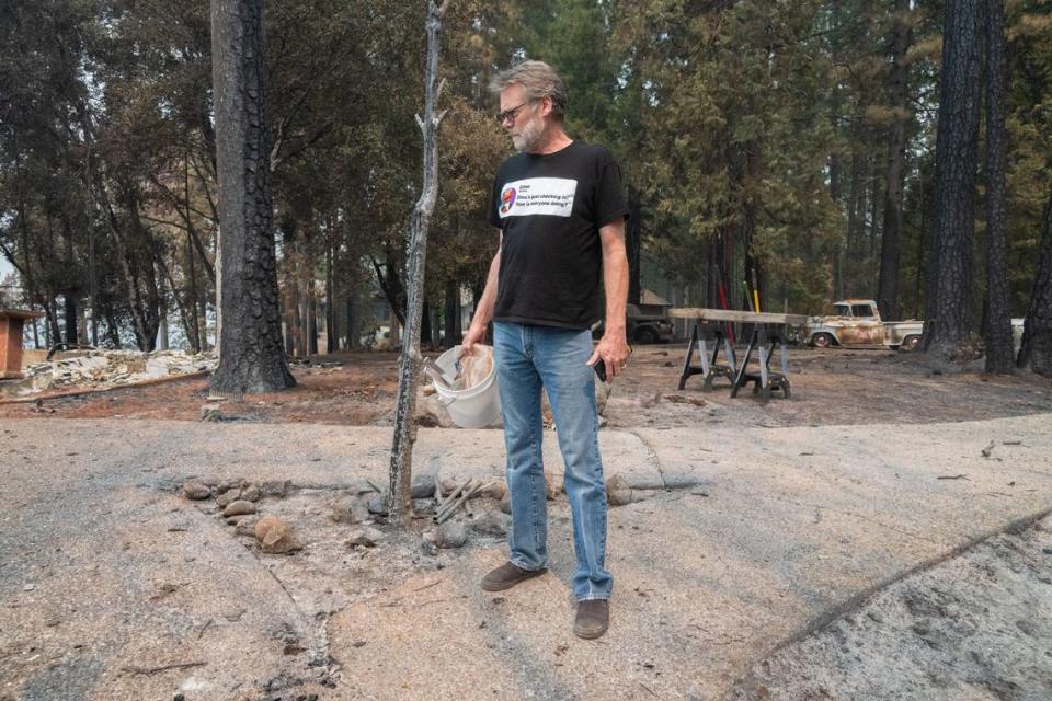 Dennis Fischer stands on a sidewalk near the remains of his home in Forest Ranch on Wednesday. Fischer, whose shirt reads, “Elmo’s just checking in! How is everyone doing?” said he wore the shirt intentionally to bring humor to an otherwise heavy day.