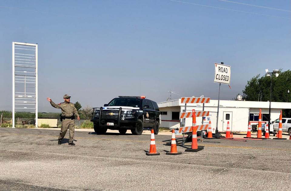 A Texas Department of Public Safety trooper redirects traffic at a roadblock at U.S. Highway 277 and FM 1235 Friday. The highway near View remained closed to FM 89 Friday morning because of the Mesquite Heat Fire.