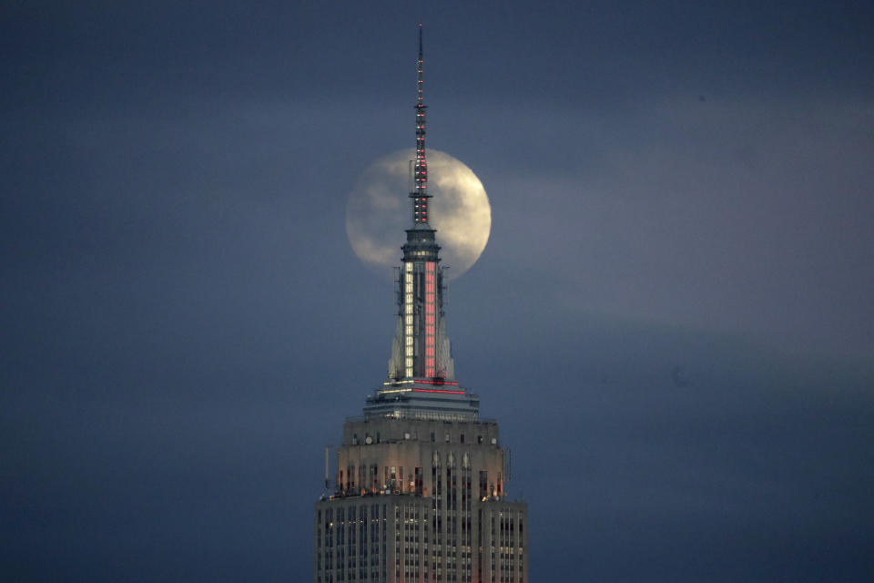 The moon is seen in its waxing gibbous stage as it rises behind the Empire State Building, Sunday, Jan. 20, 2019, seen from Jersey City, N.J. The moon will experience a lunar eclipse, when the earth moves directly between the sun and the moon, and will be seen across the United States late Sunday night. (AP Photo/Julio Cortez)