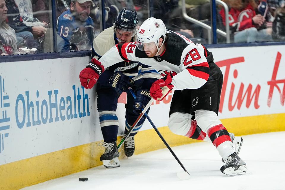 Blue Jackets center Cole Sillinger (34) fights for a puck with New Jersey Devils defenseman Damon Severson (28) during a February game that Columbus lost 3-2.