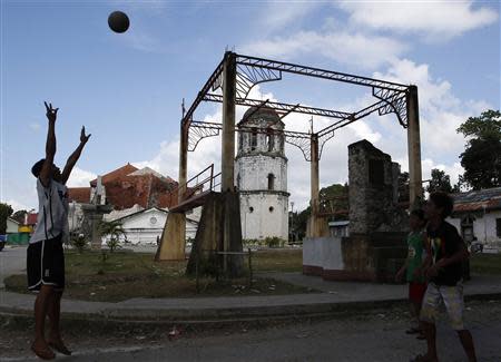 Boys play ball near a damaged Holy Trinity parish church in Loay, Bohol, after an earthquake struck central Philippines October 17, 2013. REUTERS/Erik De Castro