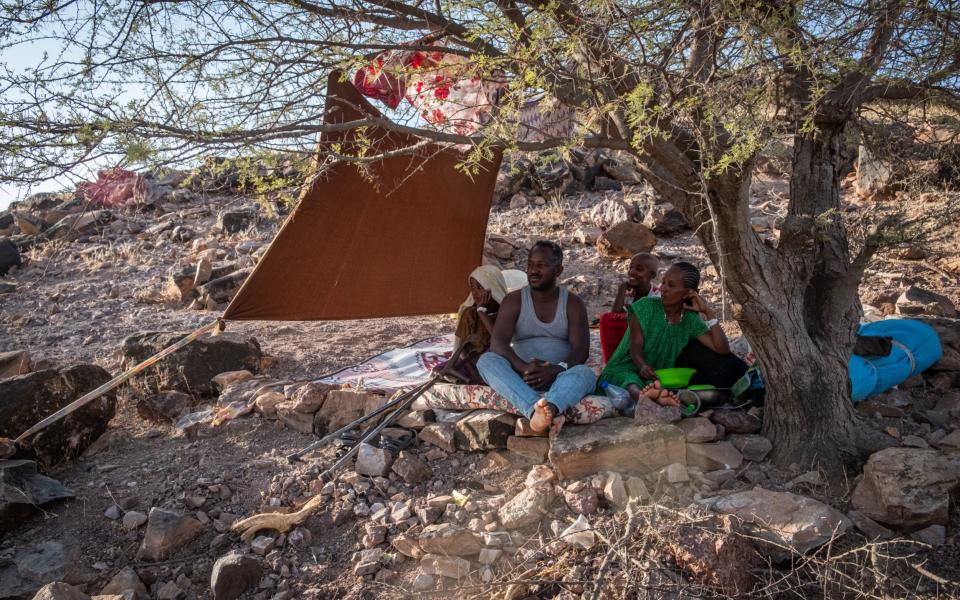 A family sits under a thorny acacia tree on one of the rolling hills that surround Um-Rakoba, a refugee camp that was built to host refugees fleeing the marxist Derg regime in 1985 - Joost Bastmeijer