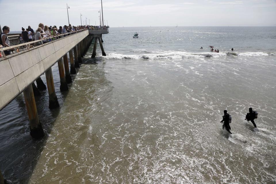 Rescue divers enter the waters near a pier for victims of a lightning strike that injured people in Venice, California July 27, 2014. (REUTERS/Jonathan Alcorn)