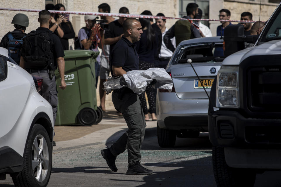 A police sapper carries an exploded rocket from a house it struck in Netivot, Israel, Tuesday, Nov. 12m 2019. Israel has killed a senior Islamic Jihad commander in Gaza in a rare targeted killing that threatened to unleash a fierce round of cross-border violence with Palestinian militants. (AP Photo/Tsafrir Abayov)