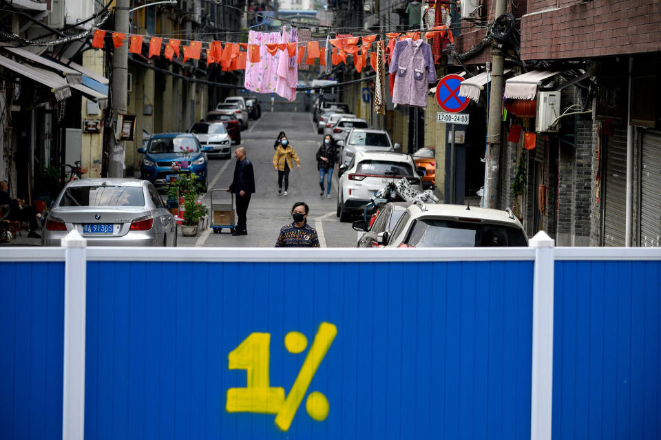 Image: People wearing face masks walk inside a barricaded residential compound in Wuhan, China, on Tuesday. (Noel Celis / AFP - Getty Images)