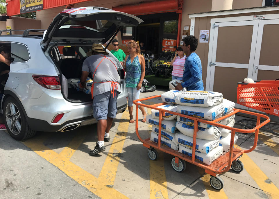 A Home Depot store employee helps to load bags of sand for customers in the Little Havana neighborhood in Miami.