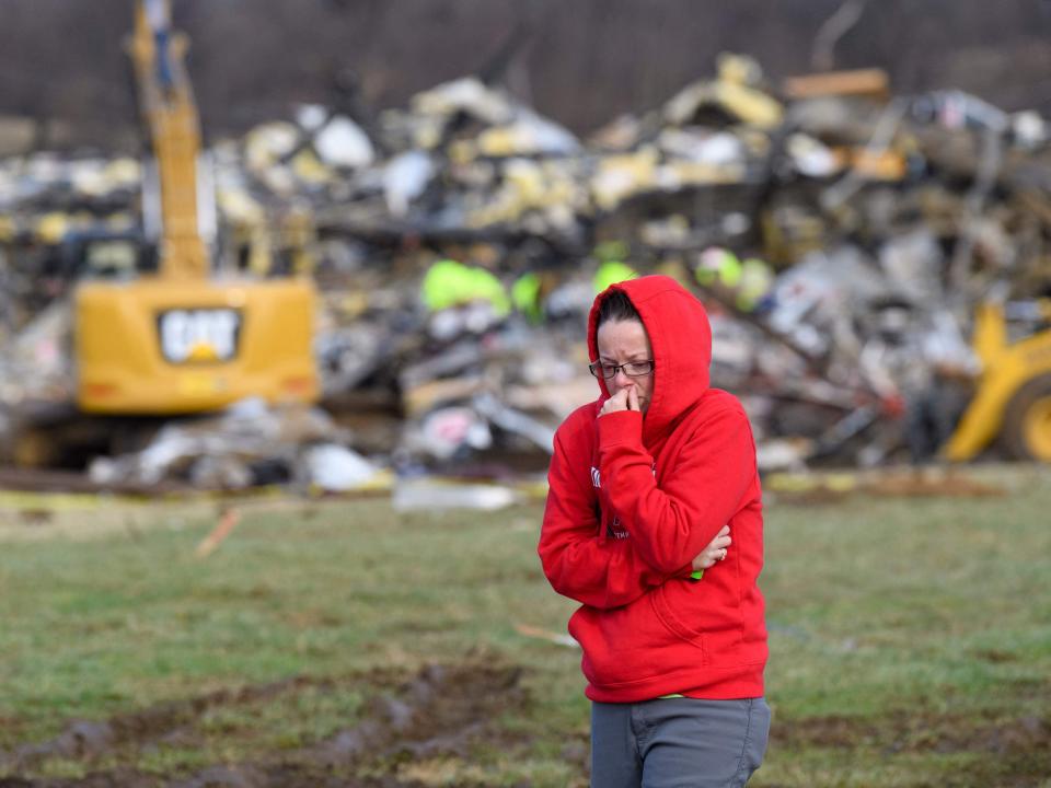 A woman walks away from what is left of the Mayfield Consumer Products Candle Factory as emergency workers comb the rubble after it was destroyed by a tornado in Mayfield, Kentucky, on December 11, 2021 (AFP via Getty Images)