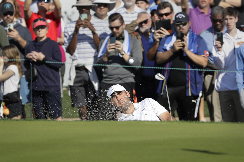 Scottie Scheffler hits out of the bunker on the 18th green during the first round of the Houston Open golf tournament Thursday, March, 28, 2024, in Houston. (AP Photo/Michael Wyke)