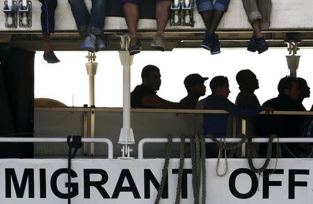 Migrants wait to disembark from the Migrant Offshore Aid Station (MOAS) ship MV Phoenix in the Sicilian harbour of Messina, Italy July 15, 2015. REUTERS/Antonio Parrinello TPX IMAGES OF THE DAY