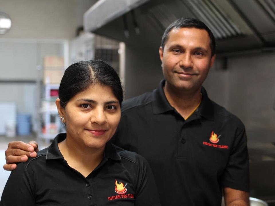 Monika (left) and Vivek Kapil (right) say it's been tough to recruit staff at their newly opened restaurant, Indian Pan Flame, in Taber, Alta. (Paula Duhatschek/CBC - image credit)