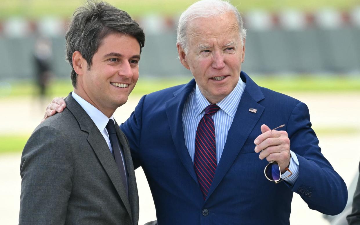 S President Joe Biden (C) is welcomed by France's Prime Minister Gabriel Attal upon arrival at Paris