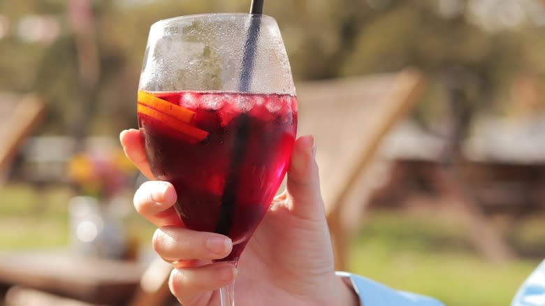 Woman's hand holding glass of sangria