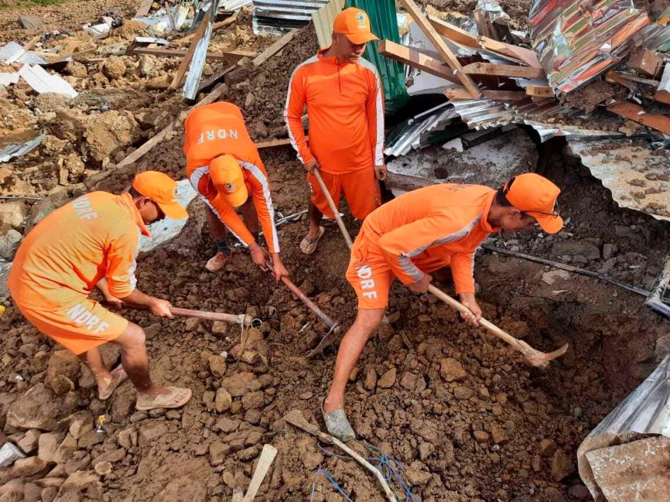 This photograph provided by India's National Disaster Response Force (NDRF) shows NDRF personnel trying to rescue those buried under the debris after a mudslide in Noney, northeastern Manipur state, India, Thursday, June 30, 2022. (National Disaster Reponse Force via AP)