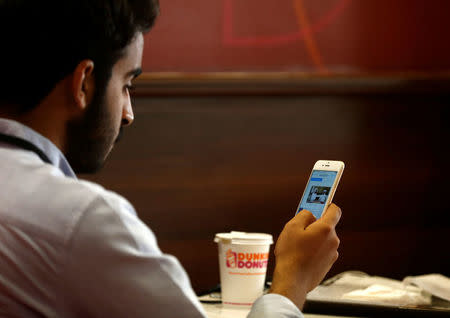 A Saudi man explores social media on his mobile device as he sits at a cafe in Riyadh, Saudi Arabia May 24, 2016. REUTERS/Faisal Al Nasser