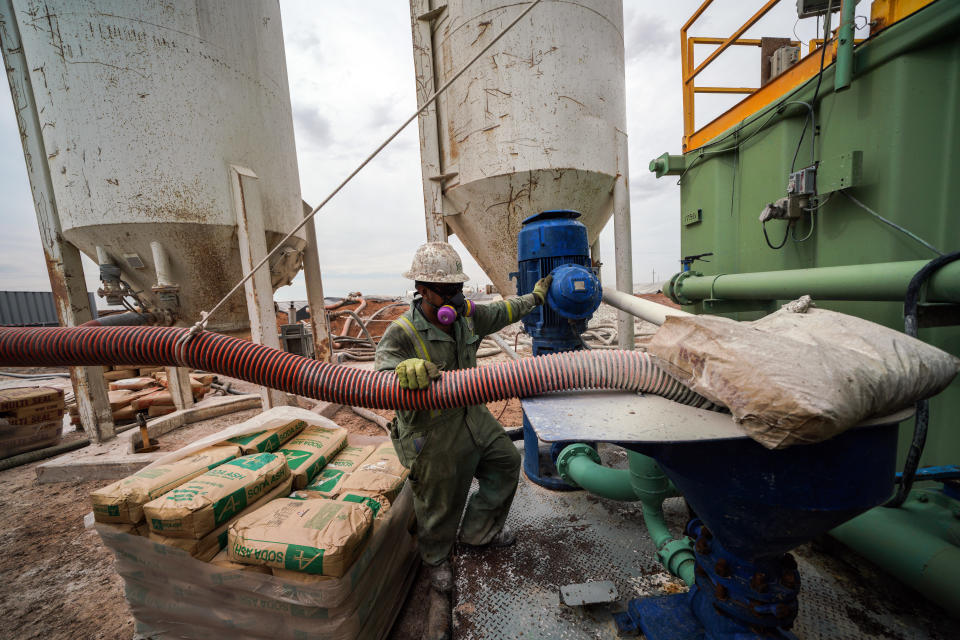 Workers extracting oil from oil wells in the Permian Basin in Midland, Texas. (Photo by Benjamin Lowy/Getty Images)