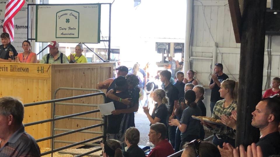 John Birdwell hugs Zachariah Stephens at the 4-H auction at the 2022 Lenawee County Fair after helping contribute through the auction to a scholarship fund in Isiah's memory.