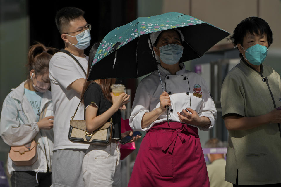 People wearing face masks wait in line to get their routine COVID-19 throat swabs at a coronavirus testing site in Beijing, Monday, Sept. 5, 2022. (AP Photo/Andy Wong)