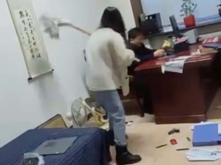 A government office worker in China went viral after she was seen in online video beating her boss with a mop.  (Weibo)