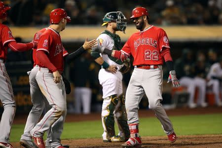 Sep 18, 2018; Oakland, CA, USA;Los Angeles Angels second baseman Kaleb Cowart (22) is congratulated at home plate after hitting a grand slam during the sixth inning against the Oakland Athletics at Oakland Coliseum. Mandatory Credit: Darren Yamashita-USA TODAY Sports