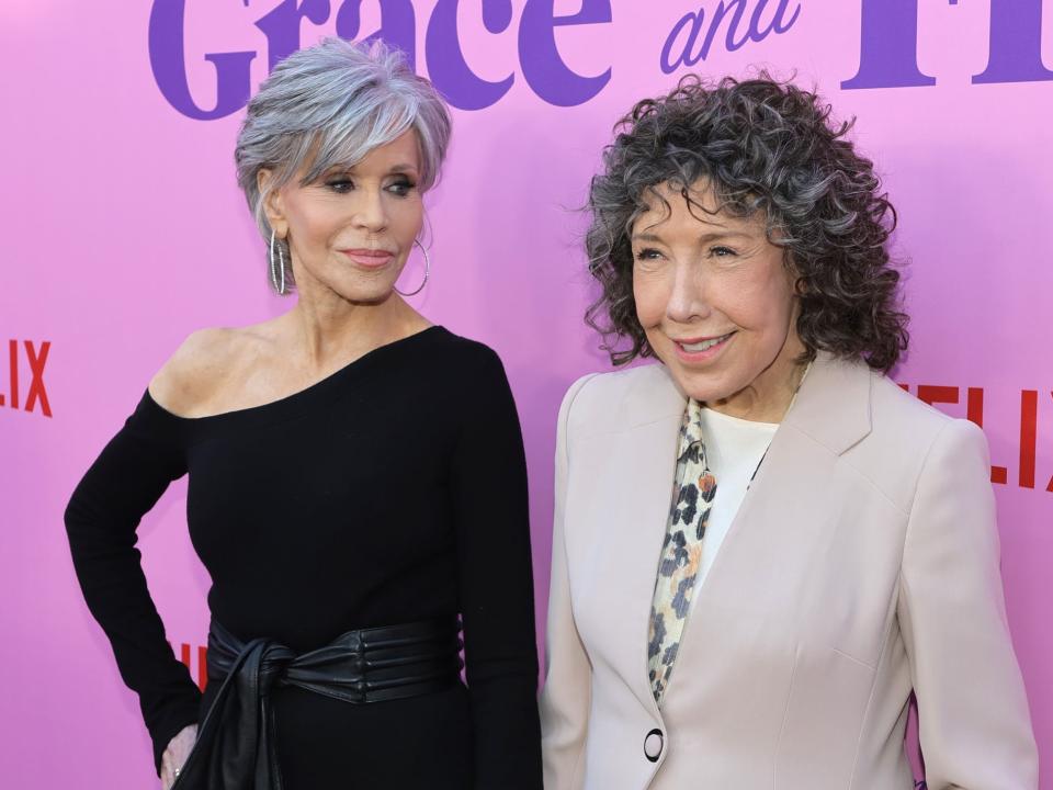 Jane smiling at Lily and the pair holding hands in front of a purple backdrop.