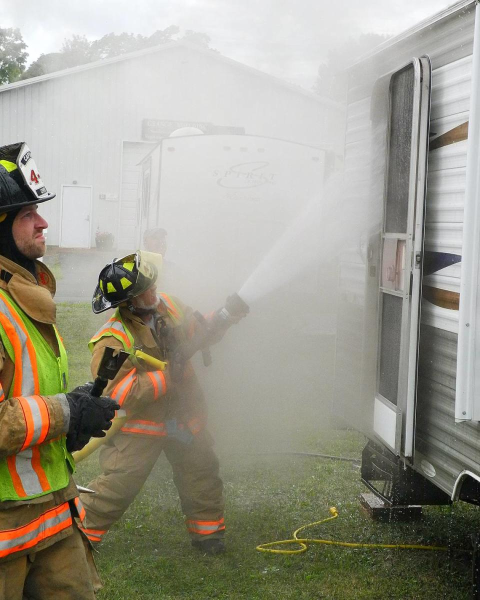 Centre Hall Fire Company Assistant Chief Harry Hockenberry sprays water into a trailer so firefighters could enter and cool hot spots Sunday, Aug. 14, 2022, at the Grange fairgrounds. People were moving in for the Grange Fair, which runs Aug. 19-27.