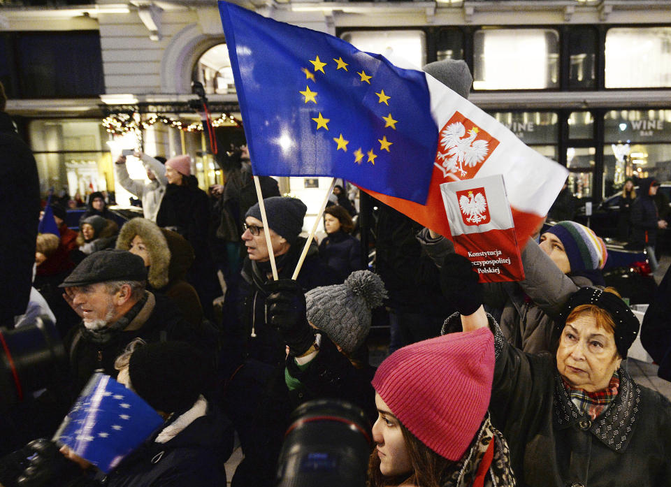FILE - In this Jan. 11, 2020 file photo, protesters carry an EU flag at an anti-government protest in Warsaw, Poland. Some Poles are afraid that a drawn-out conflict with the EU over the next budget and values could put them on a path toward an eventual departure from the bloc, or "Polexit." Poland's conservative government denies that it has ever wanted to leave the 27-member bloc and popular support for EU membership runs very high. But critics fear the combative tone of some Polish leaders could create momentum which could accidently bring the nation to the exit door.(AP Photo/Czarek Sokolowski, File)