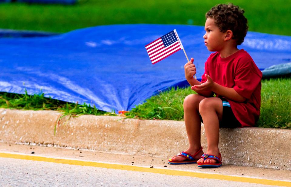 Levi Gilkey, 3, waves his American Flag as we waits for the start of the Bethany Freedom Festival Parade in Bethany, Okla. on Thursday, July 4, 2019.