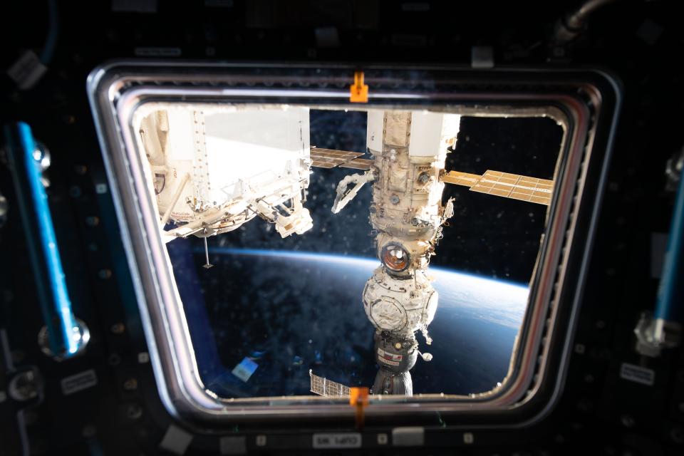 This view from one of seven windows on the International Space Station's cupola shows three Russian components including (from bottom) the Soyuz MS-21 crew ship, the Prichal docking module, and the Nauka multipurpose laboratory module.