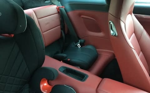 Plush booster seat in back of Porche 911 carrera coupe