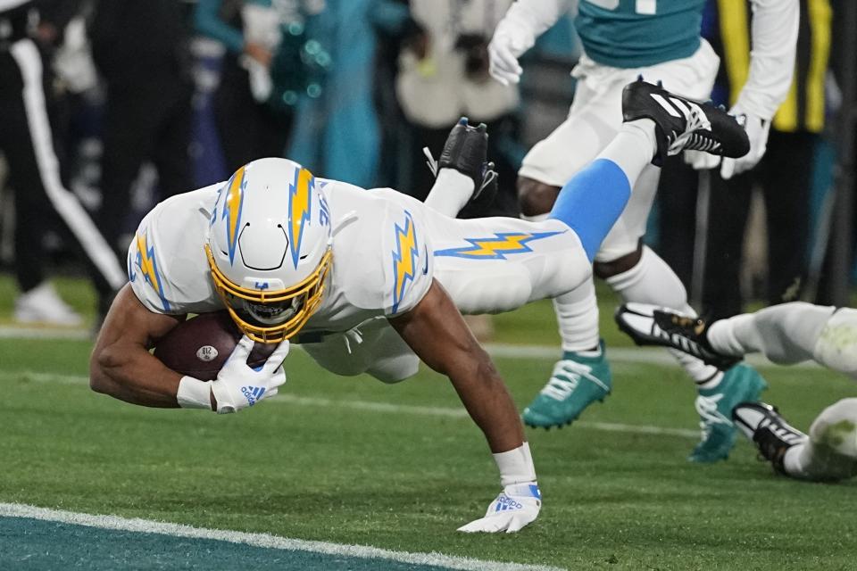 Los Angeles Chargers running back Austin Ekeler (30) leaps into the end zone after a run against the Jacksonville Jaguars during the first of an NFL wild-card football game, Saturday, Jan. 14, 2023, in Jacksonville, Fla. (AP Photo/Chris Carlson)