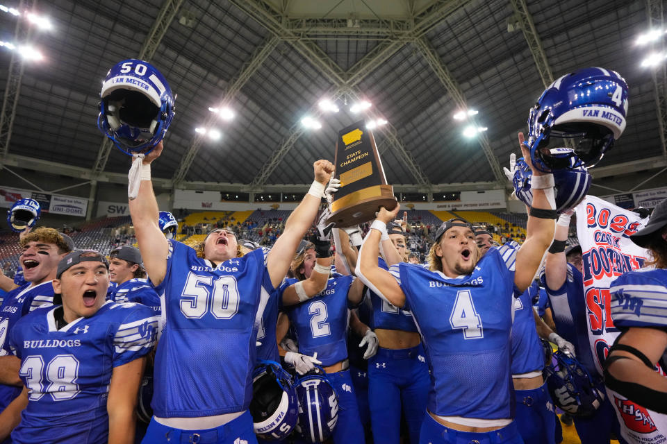 Van Meter's Ike Speltz (50) and quarterback Ben Gilliland (4) celebrate with their teammates after winning the Class 1A state championship on Friday in Cedar Falls.