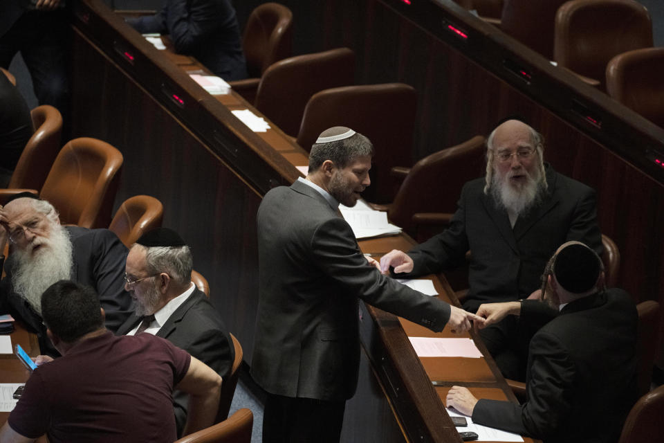 Lawmaker Bezalel Smotrich, center, leader of the Religious Zionist Party, talks with a colleague during a session of the Knesset, Israel's parliament, in Jerusalem, Monday, June 6, 2022. (AP Photo/ Maya Alleruzzo)