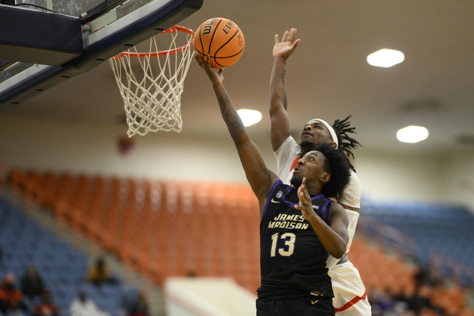 James Madison guard Michael Green III (13) goes to the basket against Morgan State guard Rob Lawson, back, during the first half of an NCAA college basketball game, Friday, Dec. 22, 2023, in Baltimore. (AP Photo/Nick Wass)