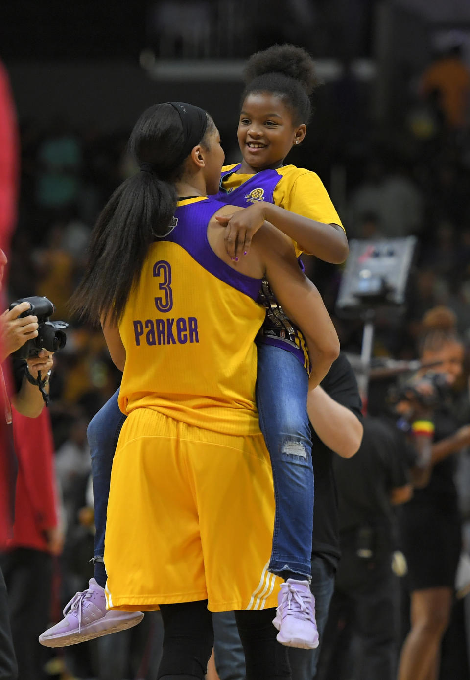 FILE- In this Sept. 29, 2017, file photo, Los Angeles Sparks forward Candace Parker holds her daughter Lailaa Nicole Williams after Game 3 of the WNBA basketball finals against the Minnesota Lynx in Los Angeles. The Sparks won 75-64. Parker and her 11-year-old daughter are braving the start of an unprecedented WNBA season together in Florida. The Los Angeles Sparks All-Star knows it’s a calculated risk to stay in the coronavirus hot spot, where all 12 teams will play games in the WNBA “bubble” of Bradenton. (AP Photo/Mark J. Terrill, File)