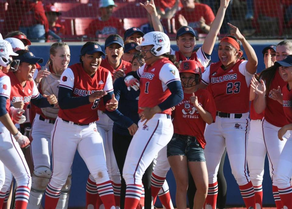Fresno State’s Keahilele Mattson, center, is welcomed at home plate after her home run in the first inning against the Nevada Wolfpack Friday, April 21, 2023 in Fresno.