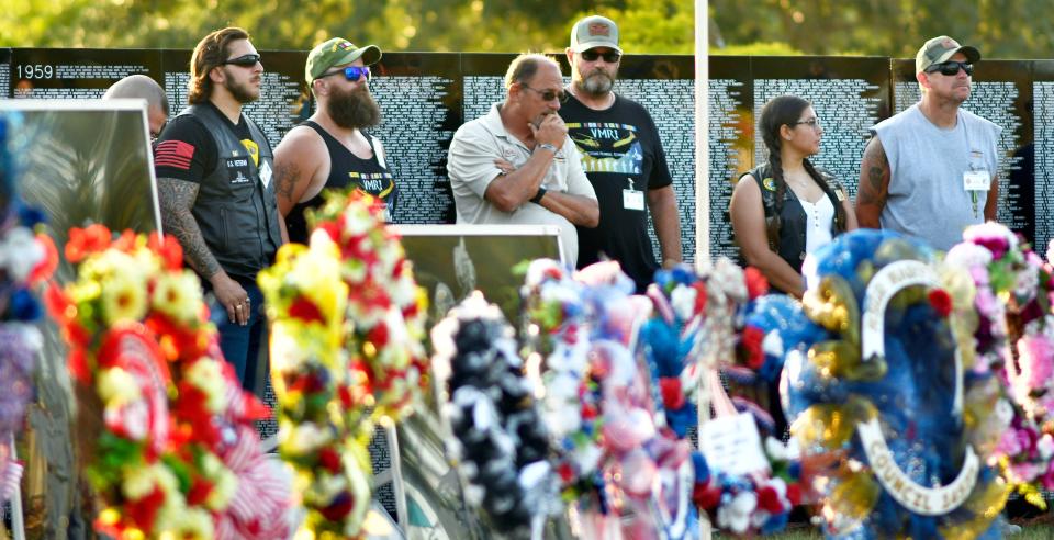 At the Monday opening ceremony, Vietnam and All Veterans of Brevard Reunion Chairman Doc Russo, center, with some of the members of Veterans Memorial Reunion, Inc., who will organize future reunions. They are standing in front of the 300 foot 3/5th scale Vietnam Traveling Memorial Wall at Wickham Park.