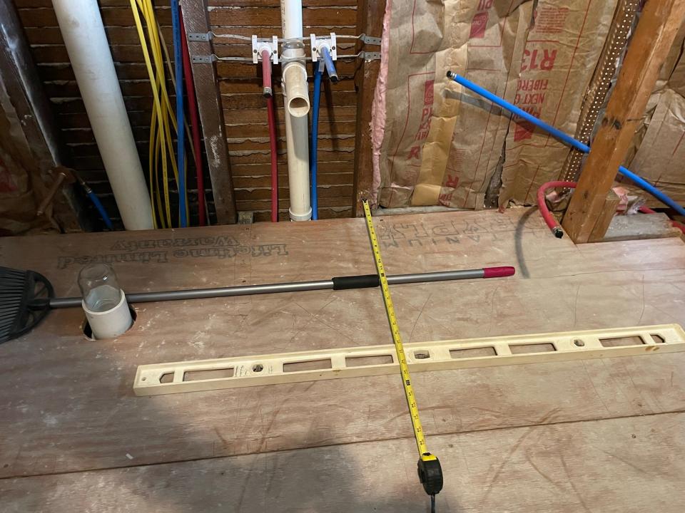 Straight edges and a ruler show where plumbing runs under the floor so that we don't screw into it.