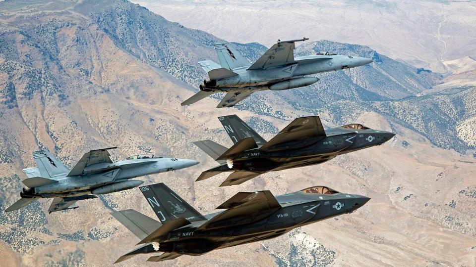 In this Sept. 3, 2015, file photo provided by the U.S. Navy, F-35C Lightning IIs, attached to the Grim Reapers of Strike Fighter Squadron (VFA) 101, and F/A-18E/F Super Hornets attached to the Naval Aviation Warfighter Development Center (NAWDC) fly over Naval Air Station Fallon's (NASF) Range Training Complex near Fallon, Nev. (Lt. Cmdr. Darin Russell/U.S. Navy via AP)