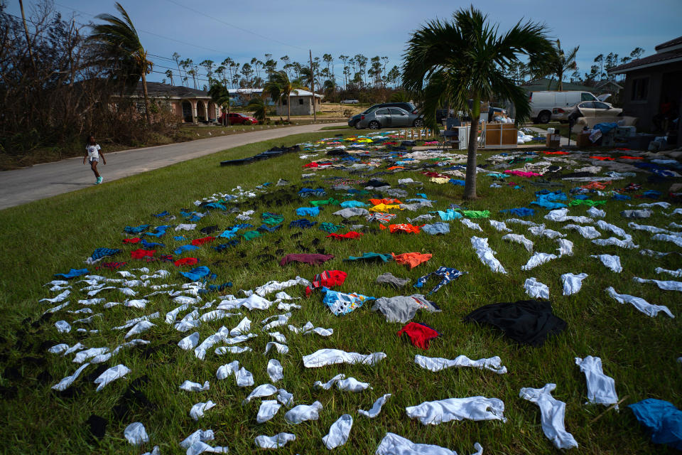 A child walks past clothes laid out to dry on a field in the aftermath of Hurricane Dorian in the Arden Forest neighborhood of Freeport, Bahamas, Sept. 4, 2019. | Ramon Espinosa—AP