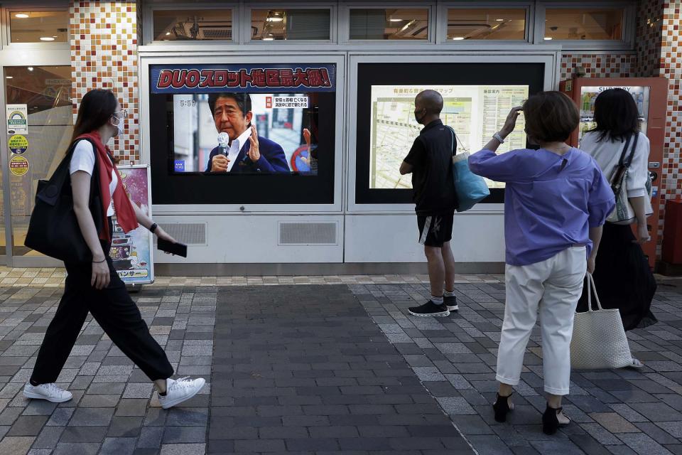  2022年7月8日，東京，行人觀看日本前首相安倍晉三的新聞廣播。