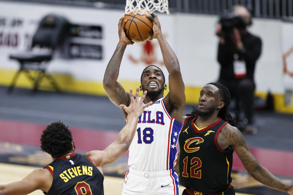 Philadelphia 76ers' Shake Milton (18) goes up for a shot between Cleveland Cavaliers' Taurean Prince (12) and Lamar Stevens (8) during the second half of an NBA basketball game Thursday, April 1, 2021, in Cleveland. (AP Photo/Ron Schwane)