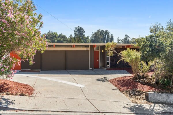 The one-level residence sits on a quiet, tree-lined street, nestled behind thick landscaping.