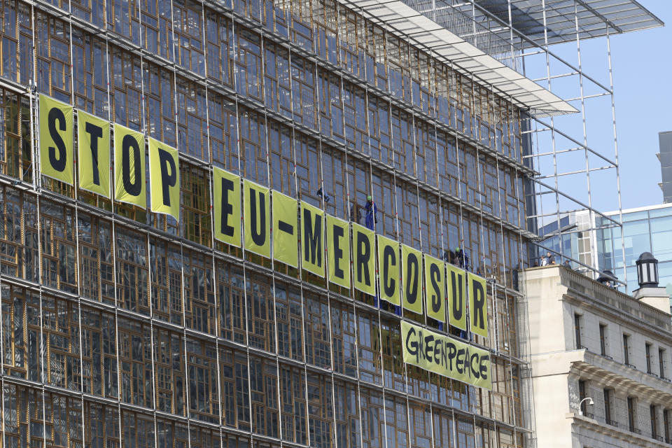 A banner, place by activist group Greenpeace, hangs on the facade of the European Council building, outside of a meeting of EU trade ministers, in Brussels, Thursday, May 25, 2023. The European Union Trade Ministers meet in Brussels Thursday to discuss, among other issues, the state of play of the trade relations with the United States and recent developments in EU-China trade relations. (AP Photo/Geert Vanden Wijngaert)