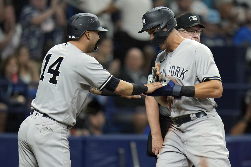 New York Yankees' Marwin Gonzalez (14) and Aaron Judge celebrate after scoring on a two-run single by Miguel Andujar off Tampa Bay Rays pitcher Ryan Thompson during the sixth inning of a baseball game Thursday, May 26, 2022, in St. Petersburg, Fla. (AP Photo/Chris O'Meara)