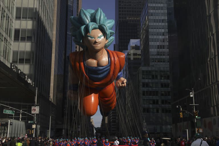 Varias personas tiran del globo de Goku por la Sexta Avenida durante el Thanksgiving Day