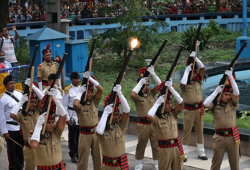 Policemen offer a gun salute next to the coffin containing the body of Indian singer KK in Kolkata