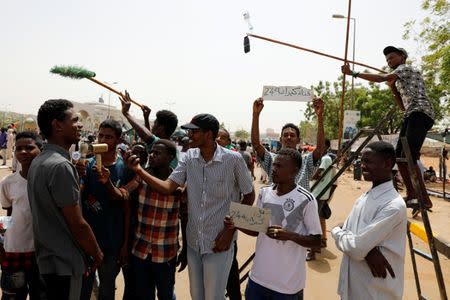 A group of protesters acting like a mock TV crew interview a demonstrator in front of the Defence Ministry in Khartoum, Sudan, April 18, 2019. REUTERS/Umit Bektas