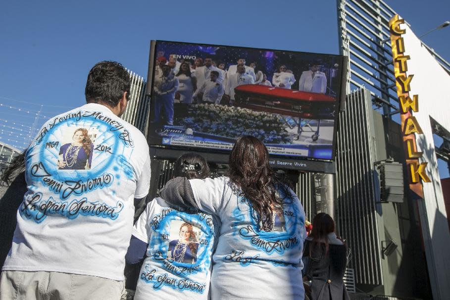 Fans mourn Jenni Rivera at a memorial televised a on giant television in Universal City in Los Angeles Wednesday, Dec. 19, 2012. The 43-year-old Rivera and six others died Dec. 9 in a crash that remained under investigation. Rivera sold more than 15 million copies of her 12 major-label albums. Her soulful singing style and honesty about her tumultuous personal life won her fans on both sides of the U.S.-Mexico border. She was also an actress and reality-TV star. (AP Photo/Damian Dovarganes)